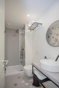 a bathroom with a sink and a toilet and a shower at Liiiving in Porto - Luxury Beachfront Apartments in Porto