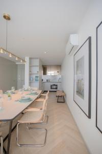 a dining room with a long table and chairs at Liiiving in Porto - Luxury Beachfront Apartments in Porto