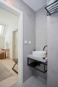 a bathroom with a white sink and a mirror at Liiiving in Porto - Luxury Beachfront Apartments in Porto