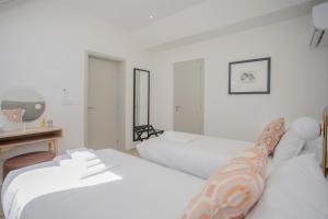 a bedroom with two beds and a desk and a television at Liiiving in Porto - Luxury Beachfront Apartments in Porto