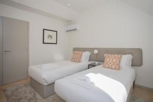 a bedroom with two beds and a couch at Liiiving in Porto - Luxury Beachfront Apartments in Porto