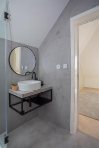 a bathroom with a sink and a mirror on a wall at Liiiving in Porto - Luxury Beachfront Apartments in Porto