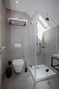 a bathroom with a glass shower and a toilet at Liiiving in Porto - Luxury Beachfront Apartments in Porto