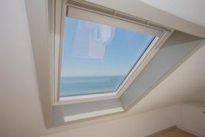 a window in a room with a view of the ocean at Liiiving in Porto - Luxury Beachfront Apartments in Porto