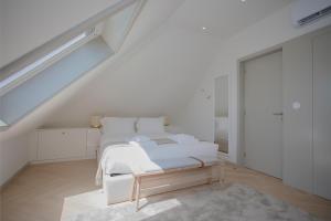 a white bedroom with a bed and a staircase at Liiiving in Porto - Luxury Beachfront Apartments in Porto