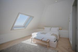 Camera bianca con letto e finestra di Liiiving in Porto - Luxury Beachfront Apartments a Porto