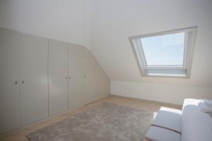 a white room with a window and a couch at Liiiving in Porto - Luxury Beachfront Apartments in Porto
