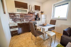una cucina con tavolo, sedie e piano di lavoro di Apartment A1 a Lubiana