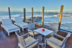 a patio with chairs and tables and a view of the ocean at Riad Mimouna in Essaouira