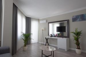 ein Wohnzimmer mit einem Tisch und einem Spiegel in der Unterkunft Siete Hotel in Antalya