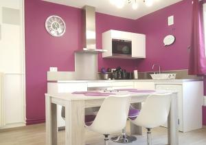 een keuken met paarse muren en een houten tafel en stoelen bij SWEETHOME DIJON - Drapeau in Dijon