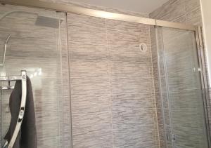 a shower with a glass door in a bathroom at SWEETHOME DIJON - Drapeau in Dijon