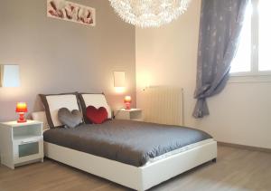a bedroom with a bed with a heart pillow on it at SWEETHOME DIJON - Drapeau in Dijon