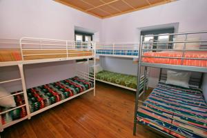 a room with three bunk beds and wooden floors at Albergue de La Estación del Río Lobos in Hontoria del Pinar