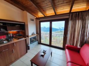 salon z czerwoną kanapą i dużym oknem w obiekcie The View Village - Villas Suites & Spa w mieście Karpenision