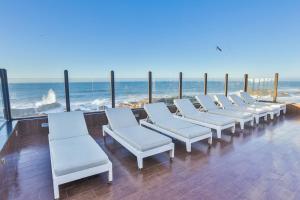 a row of white chairs sitting on the beach at Riad Mimouna in Essaouira