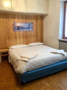 a large bed in a bedroom with wooden walls at Elegante appartamento in centro a bardonecchia in Bardonecchia
