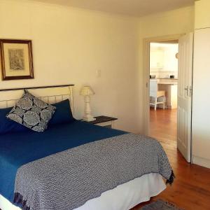 a bedroom with a bed with a blue comforter at Alfies House in Ponta Malongane
