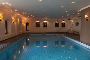 a large swimming pool with chairs in a building at Landhotel Kern in Bad Zwesten