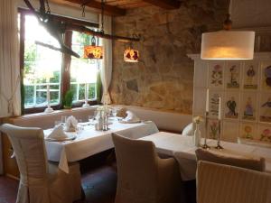 une salle à manger avec une table et des chaises blanches dans l'établissement Landhotel Kern, à Bad Zwesten