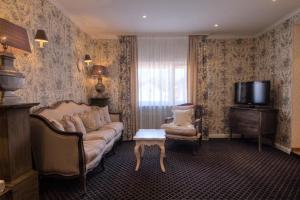 a living room with a couch and a tv at Landhotel Kern in Bad Zwesten