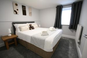 a bedroom with a bed with a teddy bear on it at Nelson By The Docks Serviced Apartments by Roomsbooked in Gloucester