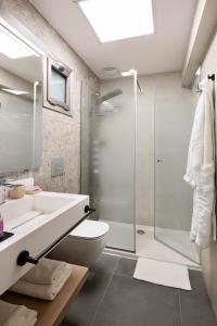 a bathroom with a shower and a toilet and a sink at Blue Dolphin Hotel in Metamorfosi