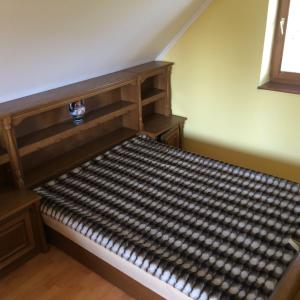 a large wooden bed in a room with at Dávid Apartman in Gárdony