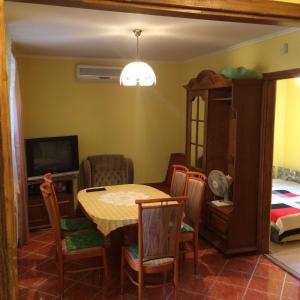 a dining room with a table and chairs and a bedroom at Dávid Apartman in Gárdony