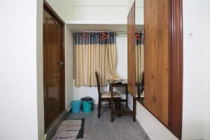 um quarto com uma mesa, uma cadeira e um espelho em Jippus Galaxy Budget Air port hotel em Cochin