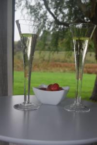 two wine glasses and a bowl of fruit on a table at Watercress Barns in Sittingbourne