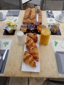 een tafel met croissants en glazen sinaasappelsap bij Sous L'Olivier in Menton