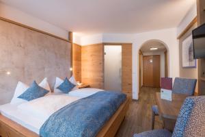 a bedroom with a large bed and a desk at Hotel Lamm in Vipiteno