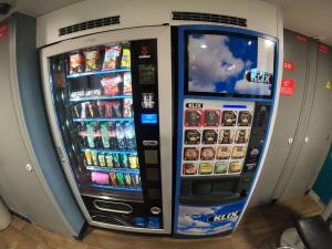 duas máquinas de venda automática com bebidas e snacks numa loja em hotelF1 Villemomble em Villemomble
