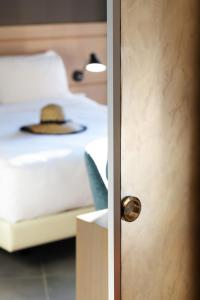 a door with a hat sitting on a bed at Blue Dolphin Hotel in Metamorfosi