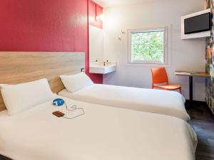 a hotel room with two beds and a sink at hotelF1 Lyon Saint Priest in Saint-Priest +95 photos