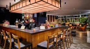 two people sitting at a bar in a restaurant at Atlanta Hotel Leipzig in Leipzig