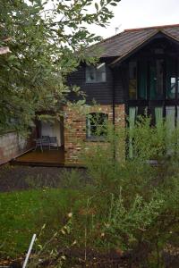 a brick house with a patio in front of it at Watercress Barns in Sittingbourne