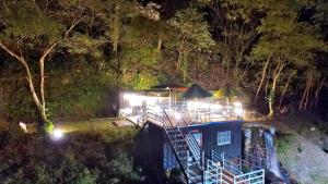 a house with lights on top of it at night at PULI GuanPu Fallsview Stay House in Puli
