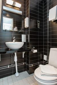 a bathroom with a toilet, sink, and mirror at Ibis Styles Stockholm Odenplan in Stockholm