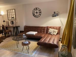 uma sala de estar com um sofá de couro castanho e uma mesa em Carpe diem em Honfleur