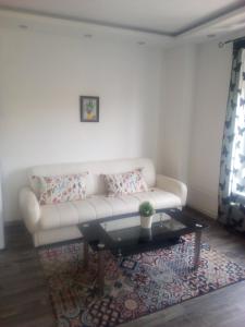 a living room with a white couch and a coffee table at Rozinka apartman in Dunaújváros