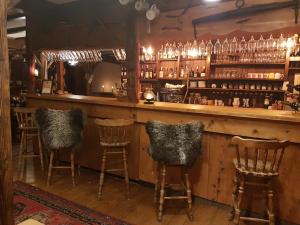 een bar met vier stoelen aan een balie bij Pension Gimmelwald in Gimmelwald