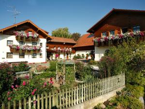a house with flowers in front of a fence at Boutique-Hotel Hasenberger in Bad Birnbach