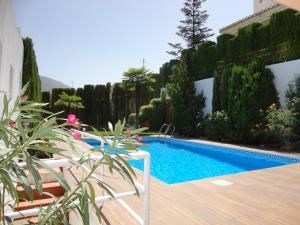 una piscina en un jardín con terraza de madera en Chalet AIRAM, en Monachil