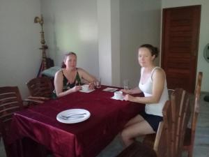 two women sitting at a table in a room at Sinharaja River Face holiday in Nelluwa