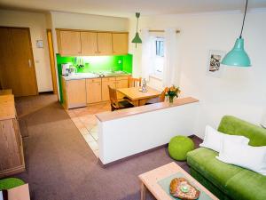 ein Wohnzimmer mit einem Sofa und einer Küche in der Unterkunft Boutique-Hotel Hasenberger in Bad Birnbach