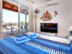 a bedroom with a bed with blue pillows and a tv at Apartment Fane De Baix I by Interhome in Llança