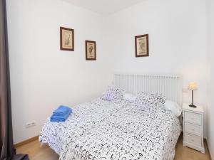 1 dormitorio con 1 cama blanca con sábanas azules y blancas en Apartment Eixample Dret Sagrada Familia by Interhome, en Barcelona