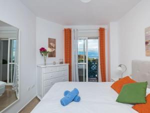 a bedroom with a white bed with blue shoes on it at Apartment El Faro by Interhome in Estepona